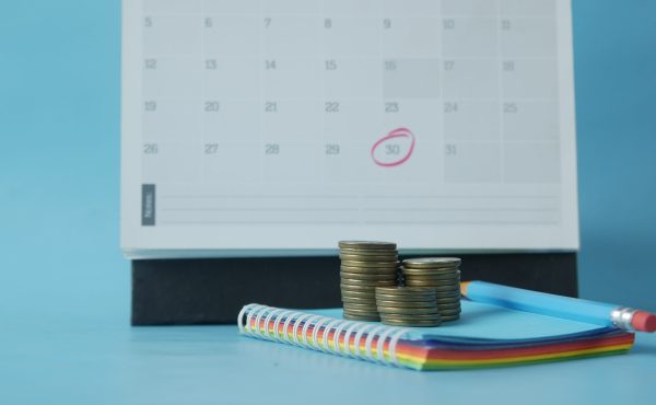 stack of coins and calendar on table .